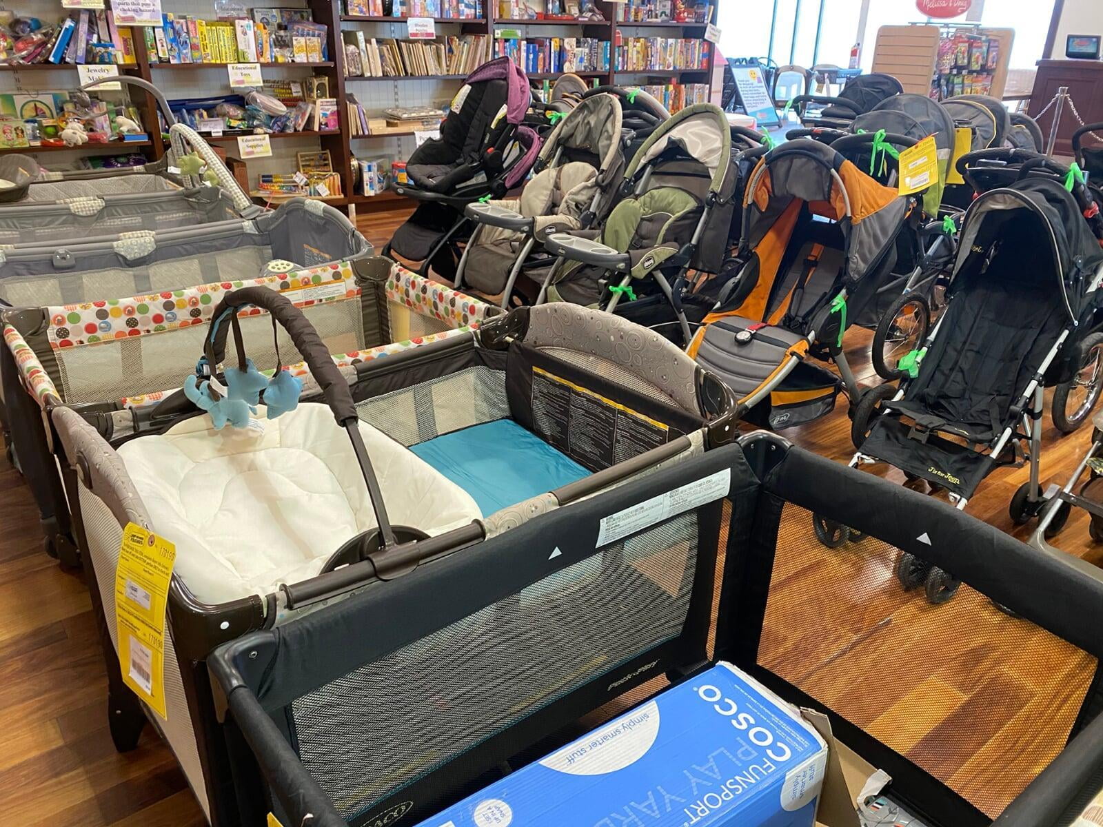 Pack 'n plays, strollers and other baby equipment sits on a hardwood basketball court floor