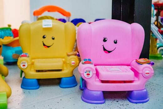 Two potty seats. One is yellow and one is pink.